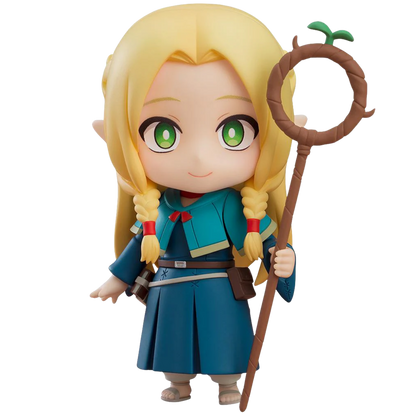 Toy figure of a character with blonde hair and green eyes, holding a staff, on a white background.