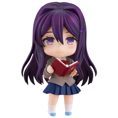 Figurine of a character with purple hair and a school uniform holding a red book on a white background