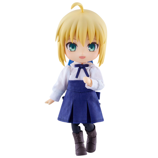 A chibi-style anime figurine of a blonde girl with green eyes, wearing a white blouse with a dark blue bow, a dark blue pleated skirt, and dark brown boots, shown against a plain white background.