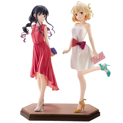 Two anime-style figurines of women in dresses on a white background