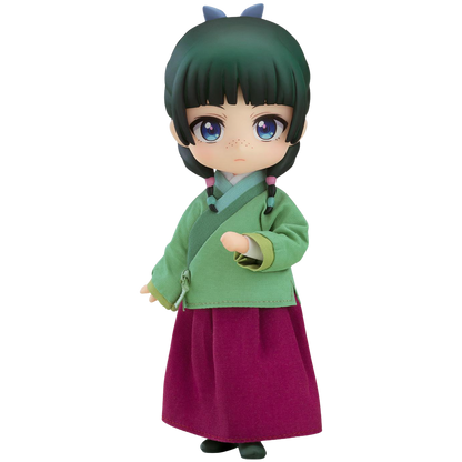 Toy figure of a character in green top and purple skirt on a white background